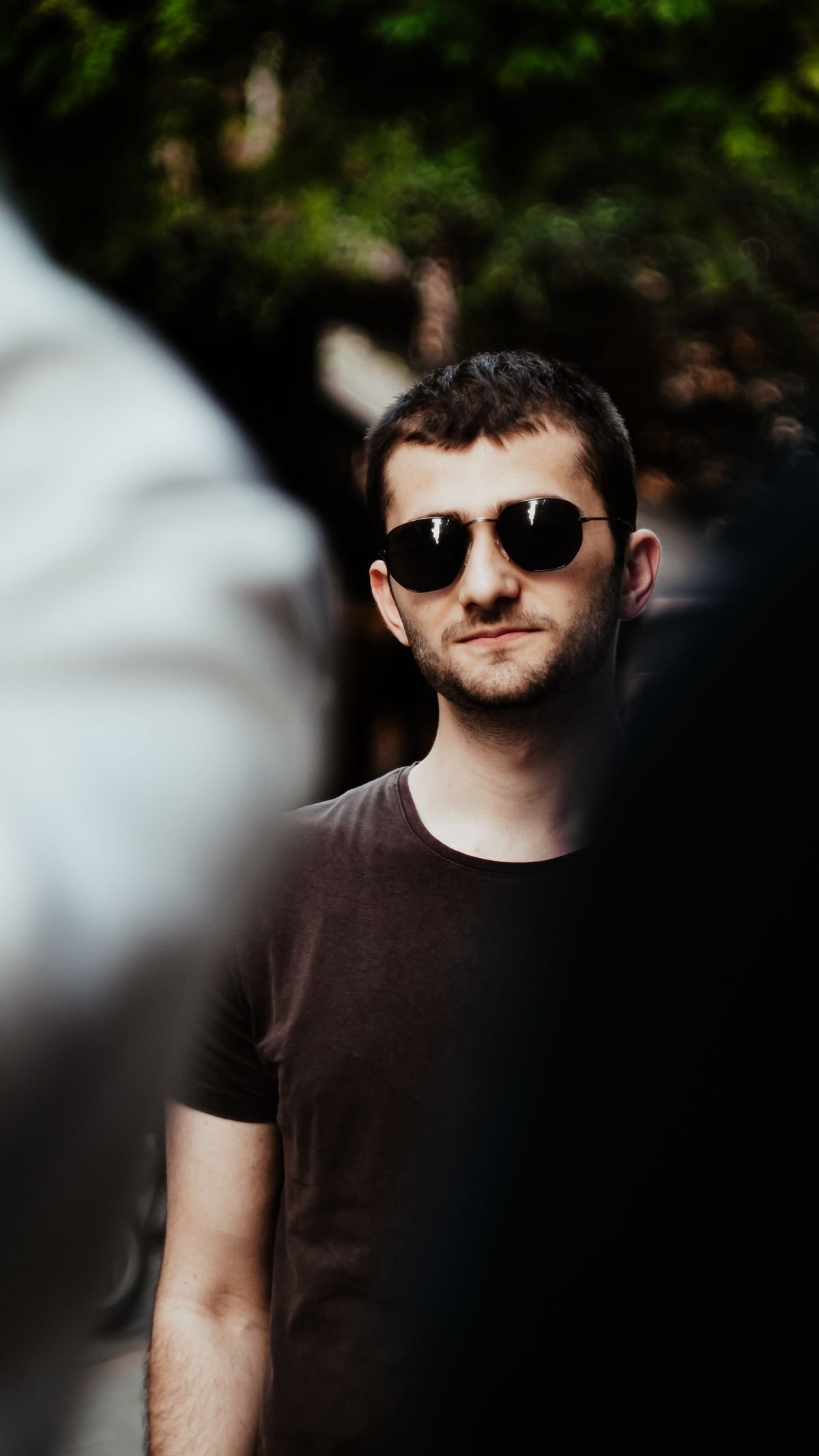 Young man wearing sunglasses in the city, showing fashion accessories for guys in 2026